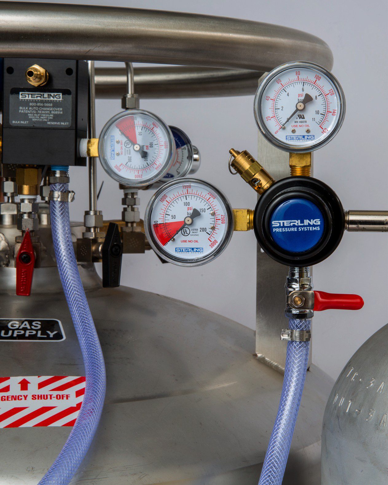 Close-up of pressure gauges and valves on industrial gas cylinders.